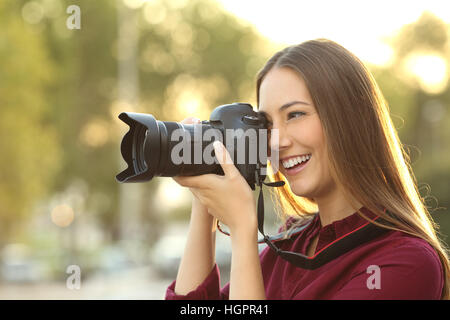 Fotografen fotografieren mit einer digitalen Kamera im Freien bei Sonnenuntergang mit warmem Licht Stockfoto