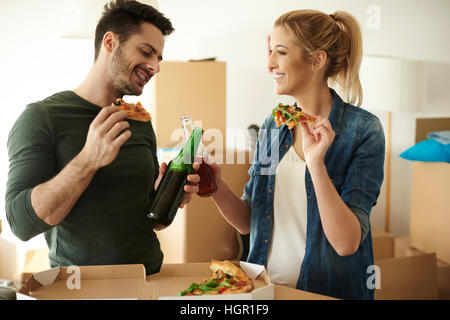 Paar Enojying, einige Getränke und Take away pizza Stockfoto