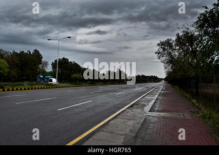 Leerer Straße in der Stadt mit dunklen Wolken im Hintergrund. Stockfoto