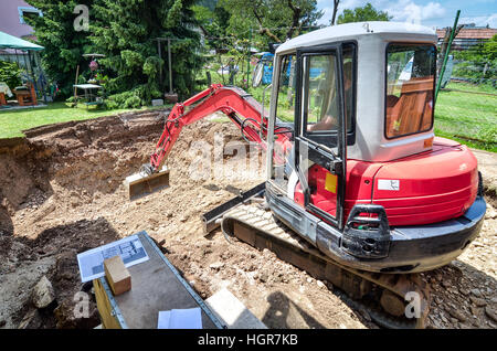 Ein Einfamilienhaus wird mit Hilfe eines Baggers wieder aufgebaut Stockfoto