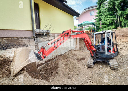 Ein Einfamilienhaus wird mit Hilfe eines Baggers wieder aufgebaut Stockfoto