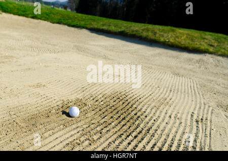 Golfball, den ich im Sandbunker auf dem Golfplatz geschnallt Stockfoto