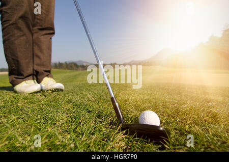 Golfspieler ist einen Golfball auf das Grün mit Fahrer Golfclub Chippen. Stockfoto