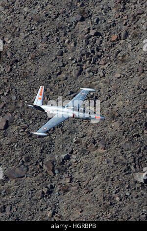 Fouga Magister, auf sehr niedrigem Niveau durch eine Wüste Schlucht fliegen. Stockfoto