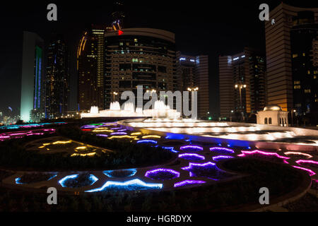 Nachtansicht des bunten Brunnen und Wolkenkratzer in Abu Dhabi, Vereinigte Arabische Emirate. Stockfoto