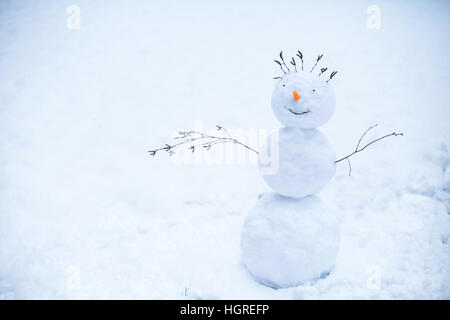 Lächelnd Schneemann stehend im Schnee Stockfoto