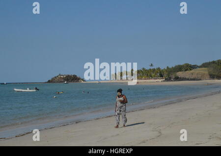 Madagassische weiblich Spaziergänge am Ufer des Andilana Beach in Nosy Be, Madagaskar. Stockfoto