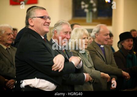 Singen Sie der Prinz von Wales und die Herzogin von Cornwall, bekannt als der Herzog und die Herzogin von Rothesay in Schottland, Auld Lang Syne während einer Aufführung von Robert Burns Poesie mit Musik von Professor Paul Mealor und Aberdeen University Chamber Choir, Glenmuick Kirche, Kirchplatz, Ballater, Aberdeenshire. Stockfoto