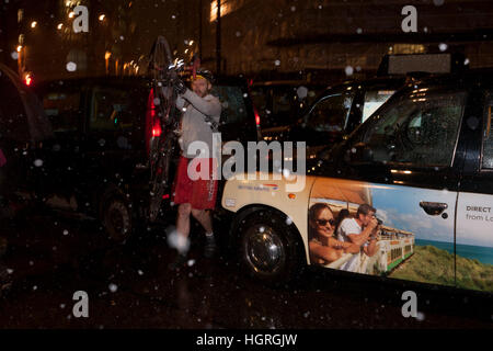 Ein Taxifahrer Protest sowie Bank-Kreuzung im Londoner Finanzdistrikt mit ihren schwarzen Taxis, zwingen Fußgänger und Radfahrer rund um den angehaltenen Fahrzeugen während der erste UK-Schnee des Winters, am 12. Januar 2017, in der City of London, England zu weben. Die Fahrer protestieren, dass Taxis und anderen Datenverkehr von hier, einer der berüchtigtsten Knotenpunkte Londons in einer bahnbrechenden Maßnahme zur Verkehrssicherheit im April starten verboten werden. Nur Radfahrer und Busse dürfen, Bank-Verbindung zwischen der Zeit von 07:00 bis 19:00 nach der City of London Corporation nach einer Reihe von c zu verwenden Stockfoto