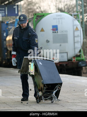 Dinslaken, Deutschland. 12. Januar 2017. Ein Polizist sammelt die Überreste ein Geldautomat am Bahnhof in Dinslaken, Deutschland, 12. Januar 2017. Ein Güterzug entgleiste in Dinslaken am 12. Januar 2017 nachdem unbekannte Täter einen Geldautomat auf der Strecke gelassen. Foto: Roland Weihrauch/Dpa/Alamy Live News Stockfoto