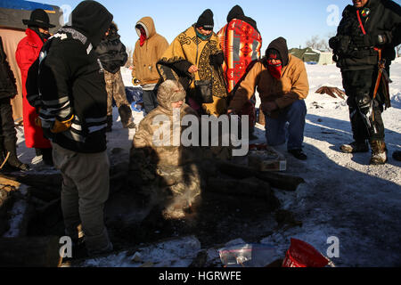 Kanonenkugel, USA. 12. Januar 2017. Gebürtige amerikanische Stammes-Mitglieder sammeln Asche nach die Heilige Löscharbeiten im Oceti Oyate Camp, früher bekannt als die Oceti Sakowin Camp in der Nähe der Standing Rock Indian Reservation nördlich von Kanonenkugel, North Dakota. Bildnachweis: ZUMA Press, Inc./Alamy Live-Nachrichten Stockfoto