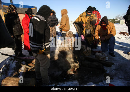 Kanonenkugel, USA. 12. Januar 2017. Gebürtige amerikanische Stammes-Mitglieder sammeln Asche nach die Heilige Löscharbeiten im Oceti Oyate Camp, früher bekannt als die Oceti Sakowin Camp in der Nähe der Standing Rock Indian Reservation nördlich von Kanonenkugel, North Dakota. e aufgeräumt und zog aus der Army Corps of Engineers Credit: ZUMA Press, Inc./Alamy Live News Stockfoto