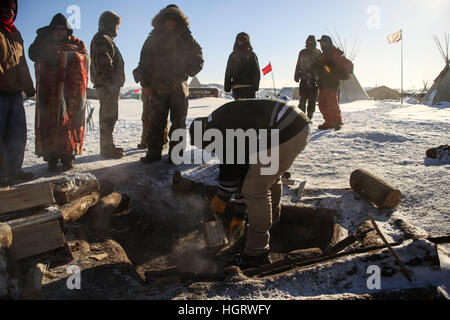 Kanonenkugel, USA. 12. Januar 2017. John Eagleshield Jr. von der Standing Rock Sioux Stammes sammelt Asche aus der erloschenen heiligen Feuer auf den Oceti Oyate Camp, früher bekannt als die Oceti Sakowin Camp in der Nähe der Standing Rock Indian Reservation nördlich von Kanonenkugel, North Dakota. e aufgeräumt und zog weg von Ar-Credit: ZUMA Press, Inc./Alamy Live News Stockfoto