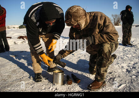 Kanonenkugel, USA. 12. Januar 2017. John Eagleshield Jr. Standing Rock Sioux Stammes (links) und Manape Lamere der Mdewakanton, Isanti und Ihanktonwan Stämme (rechts) zu sammeln, dass Asche aus der erloschenen heiligen Feuer auf den Oceti Oyate Camp, früher bekannt als die Oceti Sakowin Camp in der Nähe der Standing Rock Indian Reservation nördlich von Kanonenkugel, North Dakota. Bildnachweis: ZUMA Press, Inc./Alamy Live-Nachrichten Stockfoto