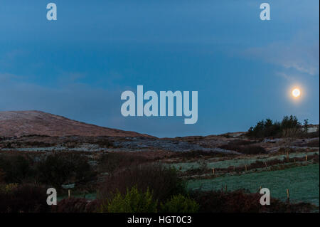 Ballydehob, Irland. 13. Januar 2017.  Eine 98 % abnehmenden Crescent Moon setzt über Mount Corrin, in der Nähe von Ballydehob, West Cork nach über Nacht Temperaturen unter dem Gefrierpunkt, stürzte. Dies führte zu starkem Frost an diesem Morgen, Rendern die Landstraßen sehr tückisch. © Andy Gibson/Alamy Live-Nachrichten. Stockfoto