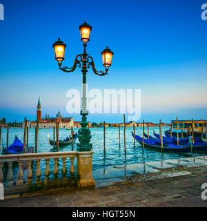 Venedig, Straßenlaterne und Gondeln oder Gondeln auf einem blauen Sonnenuntergang Dämmerung und San Giorgio Maggiore Kirche Wahrzeichen auf Hintergrund. Italien, Europa. Stockfoto