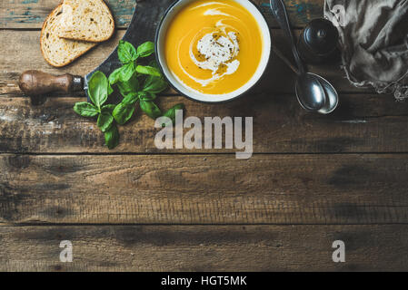 Kürbis Cremesuppe in Schüssel mit frischem Basilikum und Gewürzen Stockfoto