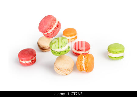 Verschiedene Arten von Makronen in Bewegung fallen oder fliegen auf weißem Hintergrund. Traditionelle französische Dessert Macarons isoliert Stockfoto