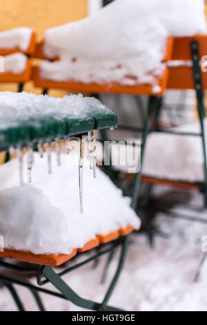 Tische und Stühle mit Eiszapfen mit einer dicken Schneeschicht bedeckt. Winter-Szene. Stockfoto