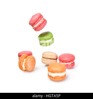 Verschiedene Arten von Makronen in Bewegung fallen oder fliegen auf weißem Hintergrund. Traditionelle französische Dessert Macarons isoliert Stockfoto