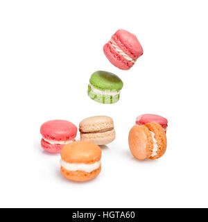 Verschiedene Arten von Makronen in Bewegung fallen oder fliegen auf weißem Hintergrund. Traditionelle französische Dessert Macarons isoliert Stockfoto