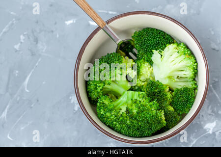 Gekochter Brokkoli in einer Schüssel auf einen konkreten Hintergrund. Stockfoto