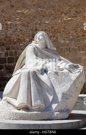 AVILA, Spanien, APRIL - 18, 2016: Die Statue von St. Theresia von Avila hinter der Stadtmauer des spanischen Bildhauers Juan Luis Vassallo 1972. Stockfoto