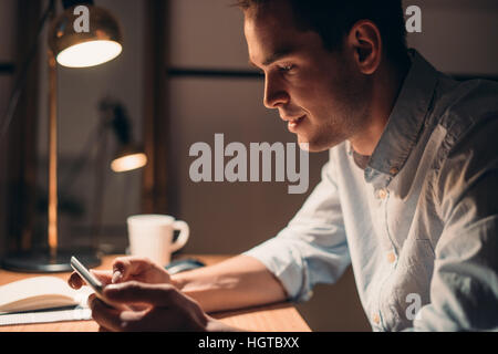 Junger Geschäftsmann auf einem digitalen Tablet spät in die Nacht arbeiten Stockfoto