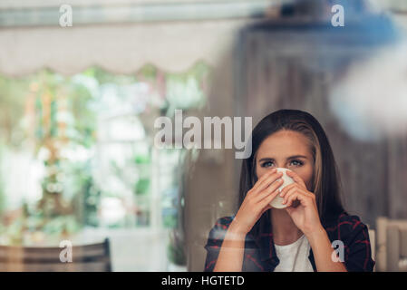 Tief in junge Frau dachte, einen Kaffee trinken Stockfoto