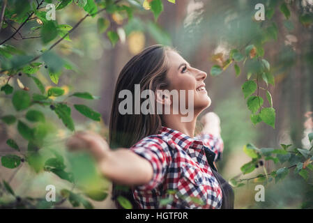 Lächelnde junge Frau, die frische Luft und Natur genießen Stockfoto
