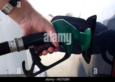 Mans Hand, die Benzin-Pumpe-Düse in Auto Tank tanken Tankstelle UK Stockfoto
