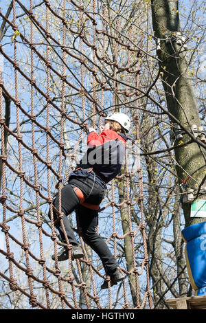 Das Mädchen klettert Hindernisse der Seilpark in klaren Sommertag Stockfoto