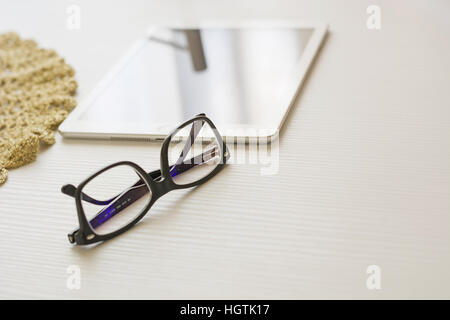 Gläser und Tablet auf einem weißen Tisch Stockfoto