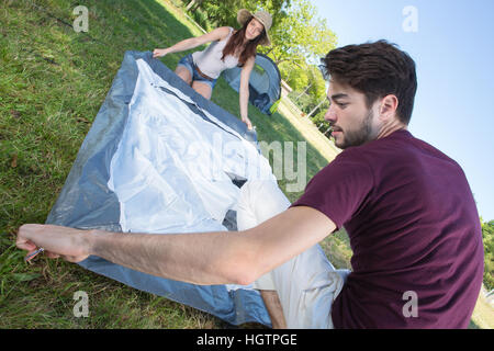 Glückliches junges Paar ihr Zelt am Campingplatz Stockfoto