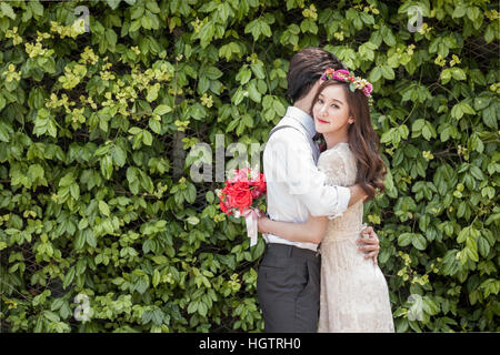 Seitenansicht des jungen Hochzeitspaar umarmt im freien Stockfoto