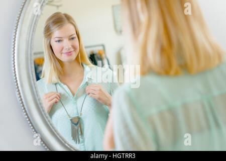 Lady Halskette vor Spiegel anprobieren Stockfoto