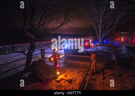 Beleuchtete Kreuze auf einem Friedhof im Süden Islands in der Nacht im Schnee, Januar 2017. Stockfoto