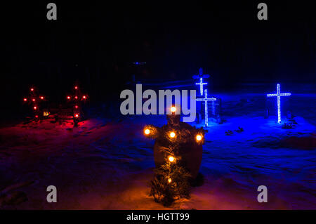 Beleuchtete Kreuze auf einem Friedhof im Süden Islands in der Nacht im Schnee, Januar 2017. Stockfoto