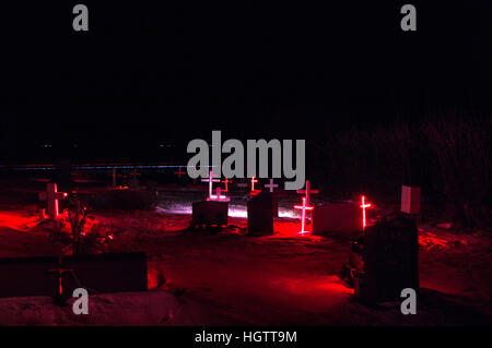 Beleuchtete Kreuze auf einem Friedhof im Süden Islands in der Nacht im Schnee, Januar 2017. Stockfoto