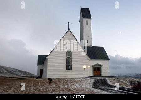 Weißer Rahmen Kirche mit einem einzigartigen Turm entlang Hvalfjördur in West Island. Stockfoto