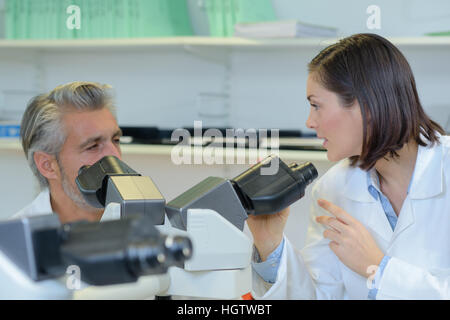 Wissenschaftler untersuchen Proben unter Mikroskop Stockfoto