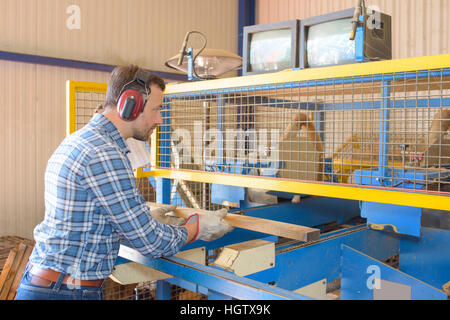 Schreiner Sägen Holzbohlen durch alte Präzisionsmaschine Stockfoto