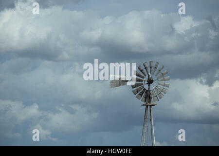 Eine Wetterfahne Windmühle in stürmischen Himmel im Central Valley von Kalifornien. Stockfoto