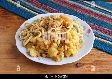 Typisch peruanische Anden Mahlzeit aus Reis, Kartoffeln, Nudeln und Huhn Stockfoto