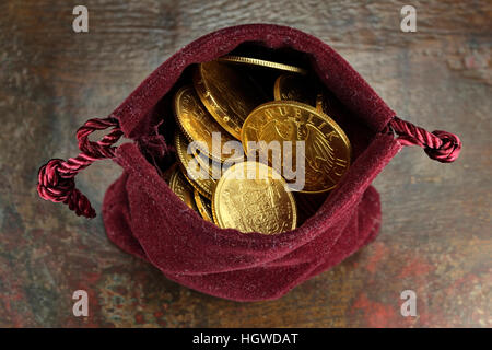 verschiedene europäische gold Umlaufmünzen aus dem 19./20. Jahrhundert in der Handtasche samt auf rustikalen hölzernen Hintergrund Stockfoto