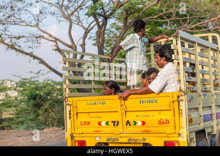 Eine Gruppe von Arbeitern in Indien eine Fahrt auf der Rückseite ein Pick-up-Fahrzeug mit geplant Seiten Stockfoto