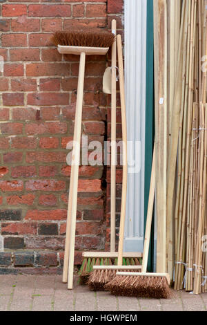 Besen mit langen hölzernen Griffen für den Verkauf außerhalb shop Stockfoto