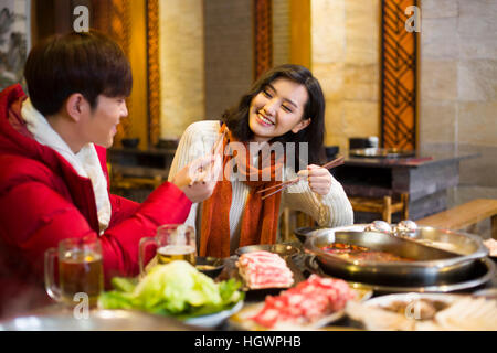 Junges Paar mit Abendessen im Hotpot restaurant Stockfoto