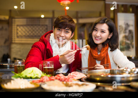 Junges Paar mit Abendessen im Hotpot restaurant Stockfoto