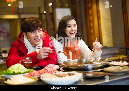 Junges Paar mit Abendessen im Hotpot restaurant Stockfoto